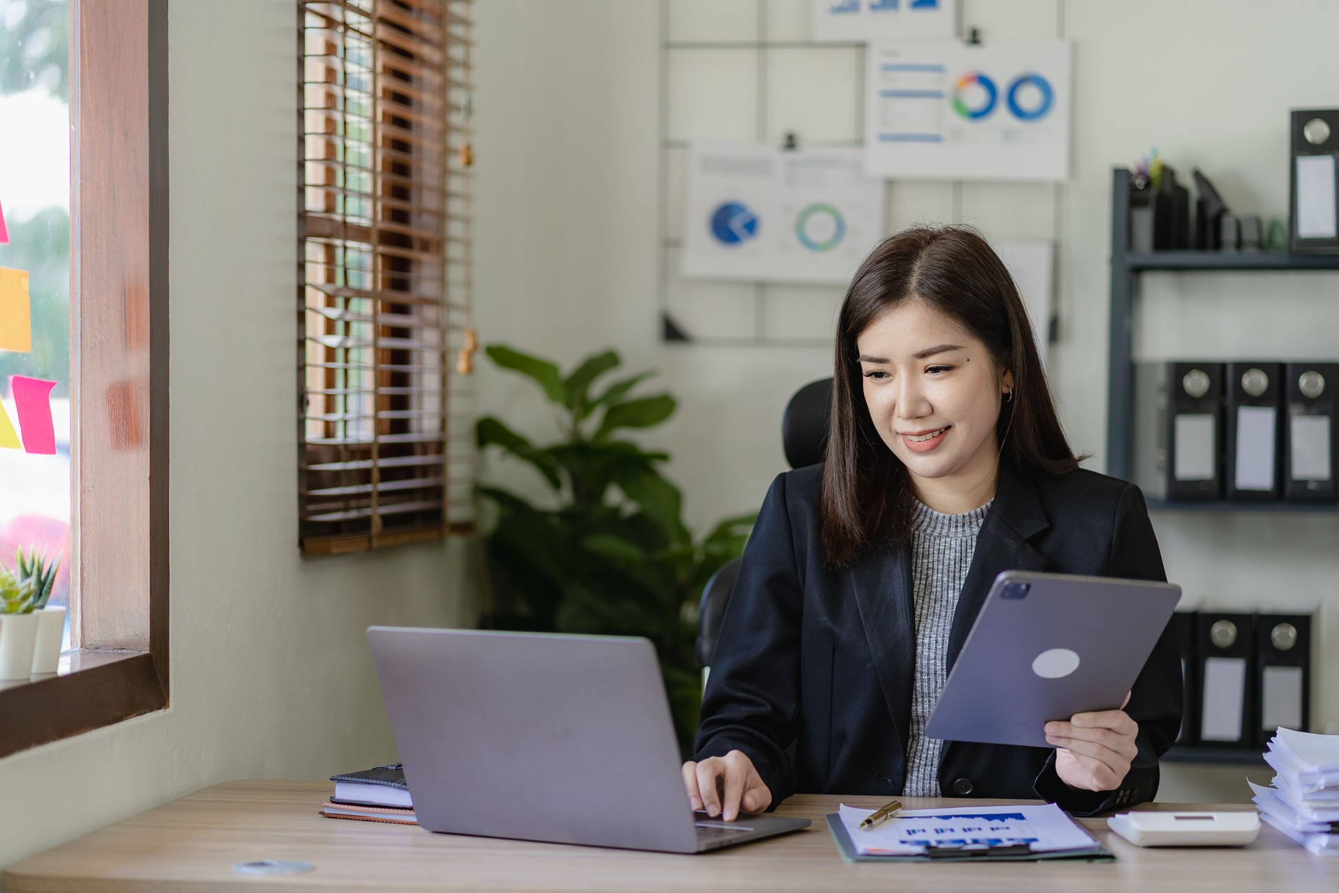 Business woman using tablet and laptop to do financial math, tax, reporting, accounting, statistics and analytical research concept. Make documents at work using your computer's online software.