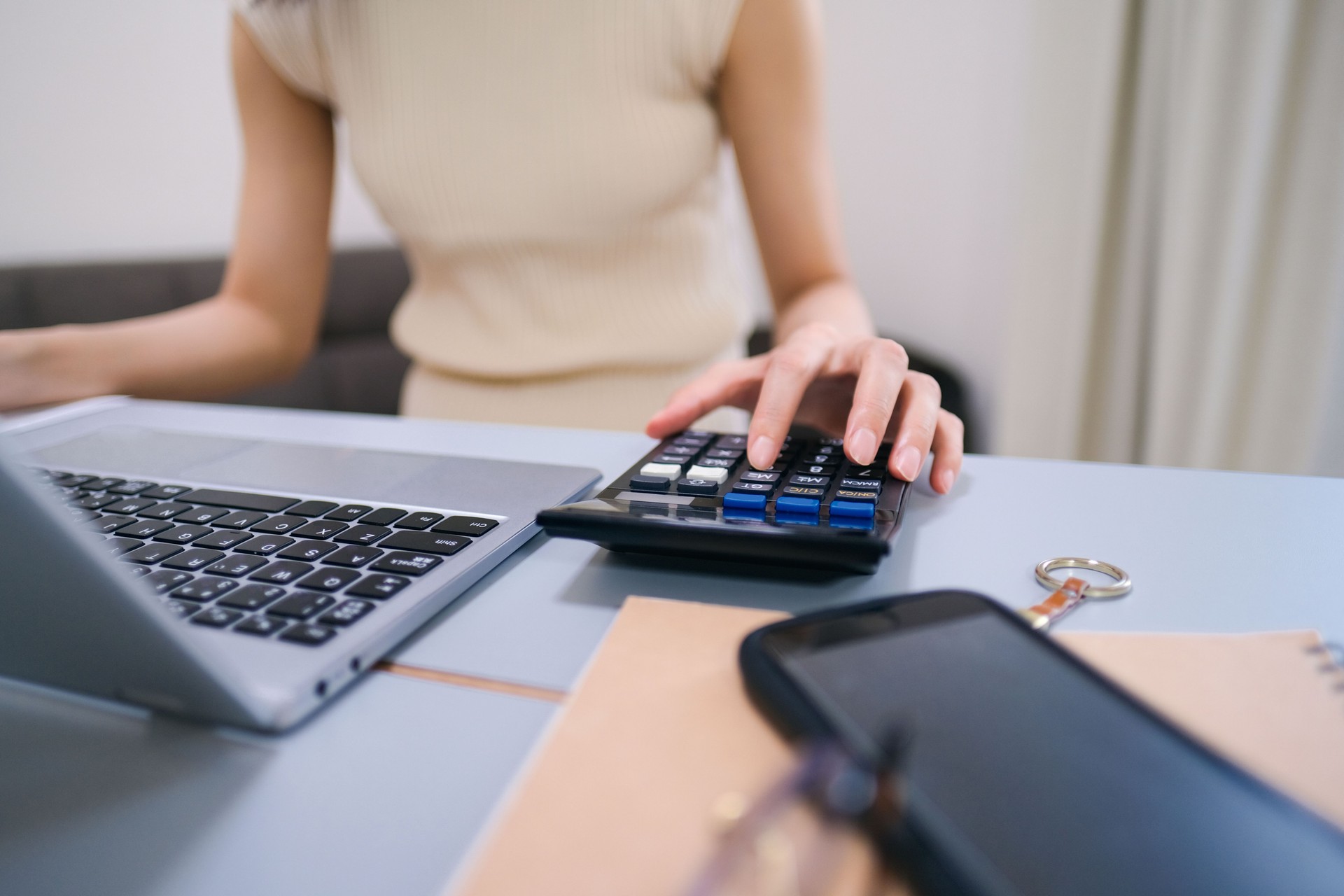 Closeup of woman's hands using calculator