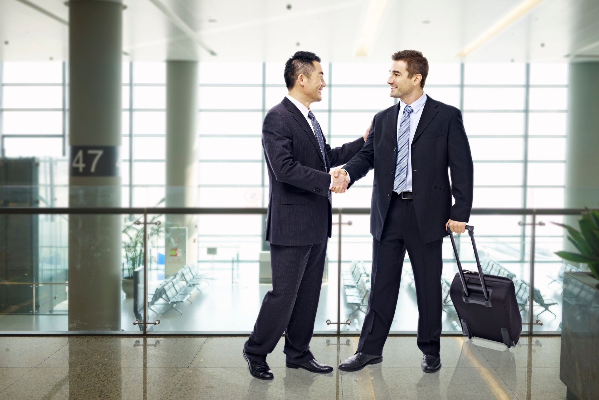 business people shaking hands at airport